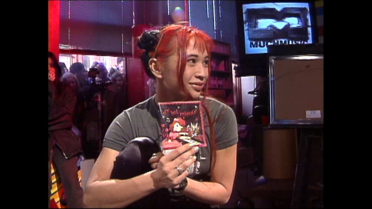 a woman holding a CD at a TV station