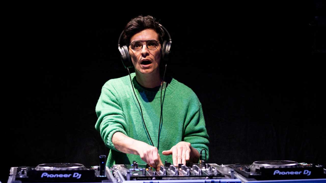 a man with headphones, turntables and a mixer