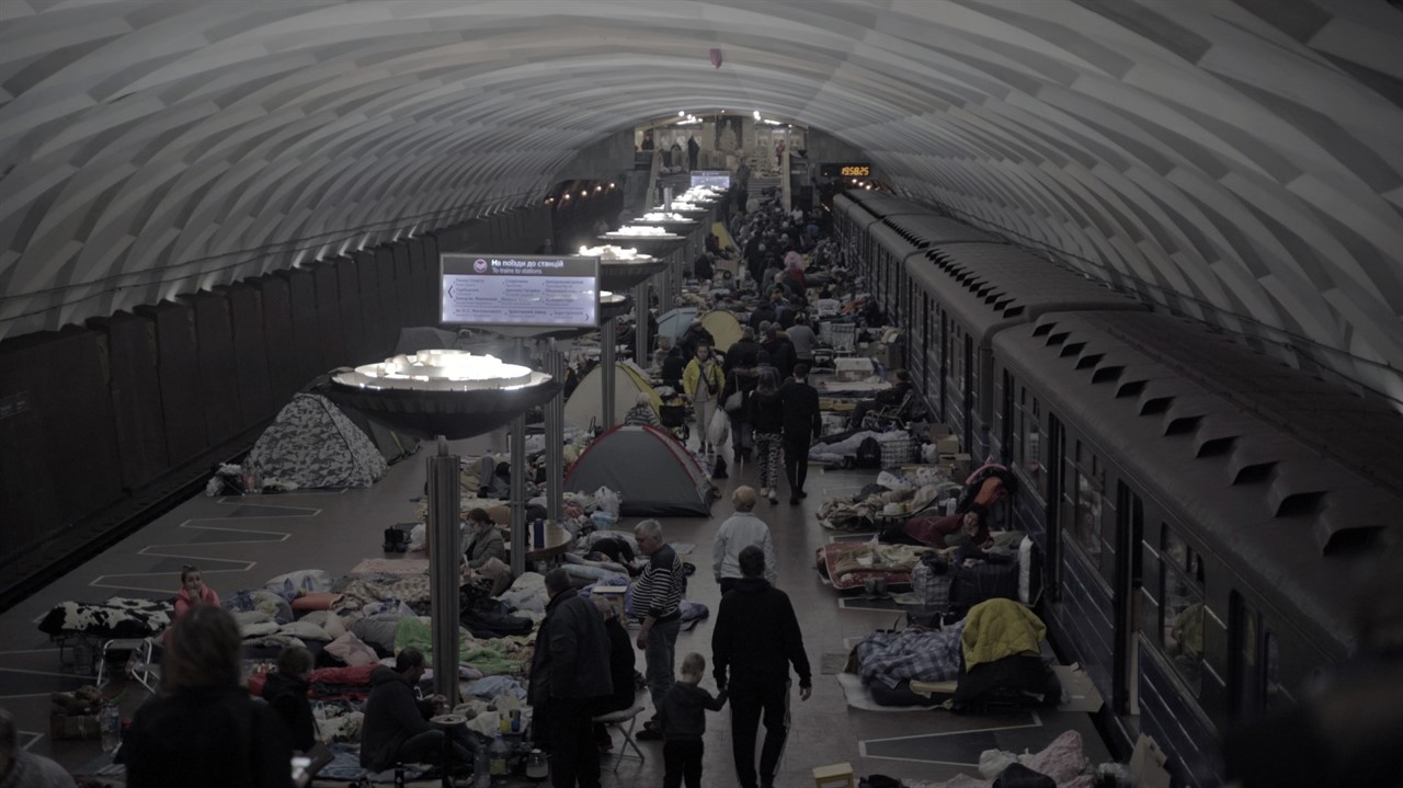 A large group of people camp in a subway tunnel