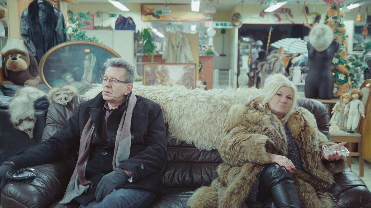 a man and a woman in fur sitting on a couch