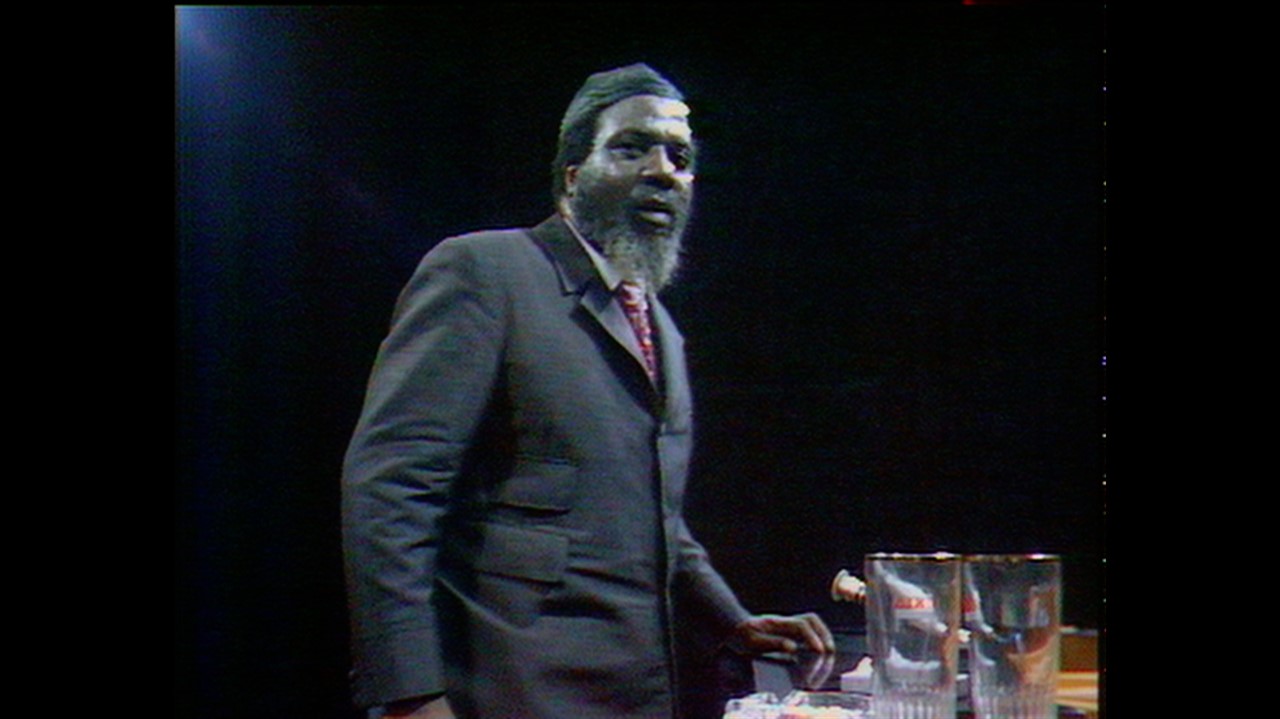 Thelonious Monk standing next to a piano