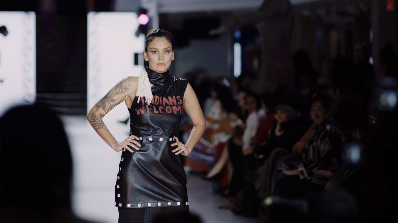 a woman on a runway with her hands on her hips