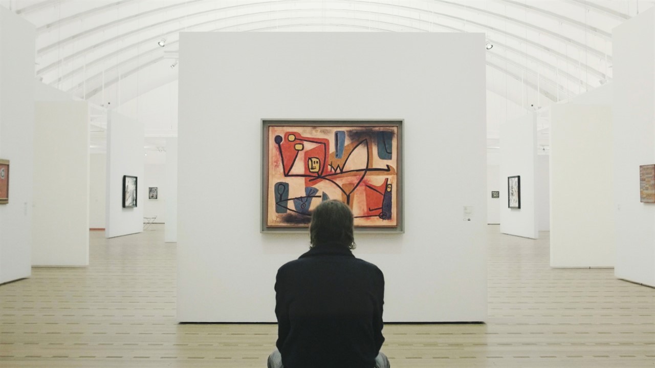 Person seen from behind in an art gallery