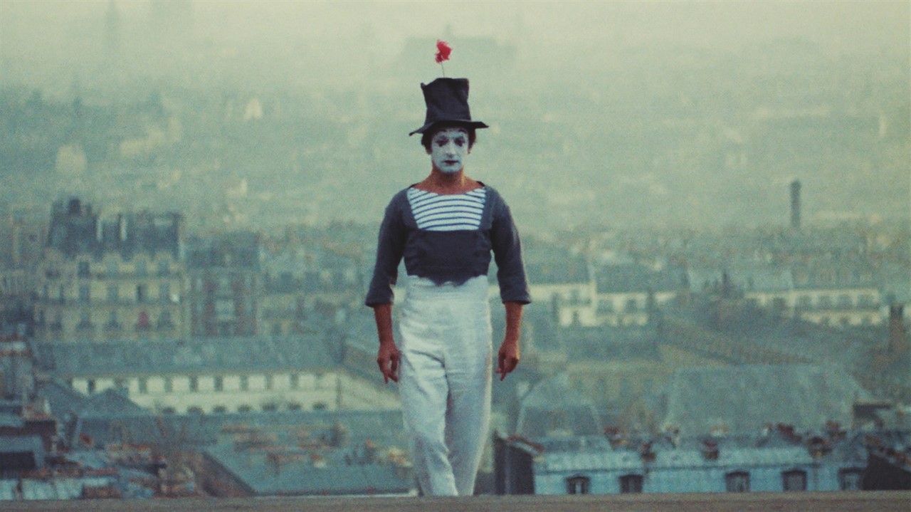 Mime with a top hat standing on a roof