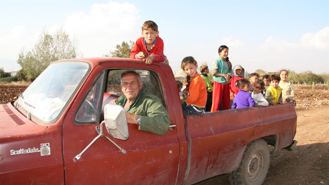 Man driving a truck full of children