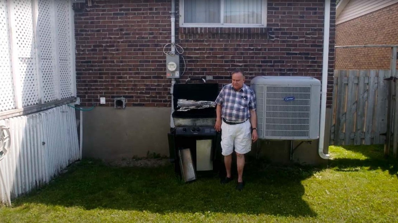 Man in shorts standing in front of barbeque