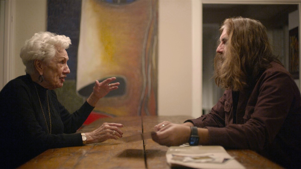 Old woman and long-haired man in conversation