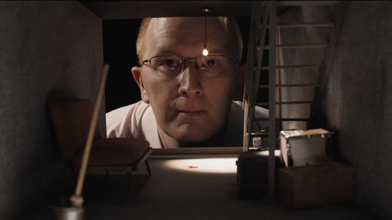 Man in glasses peers into minature basement