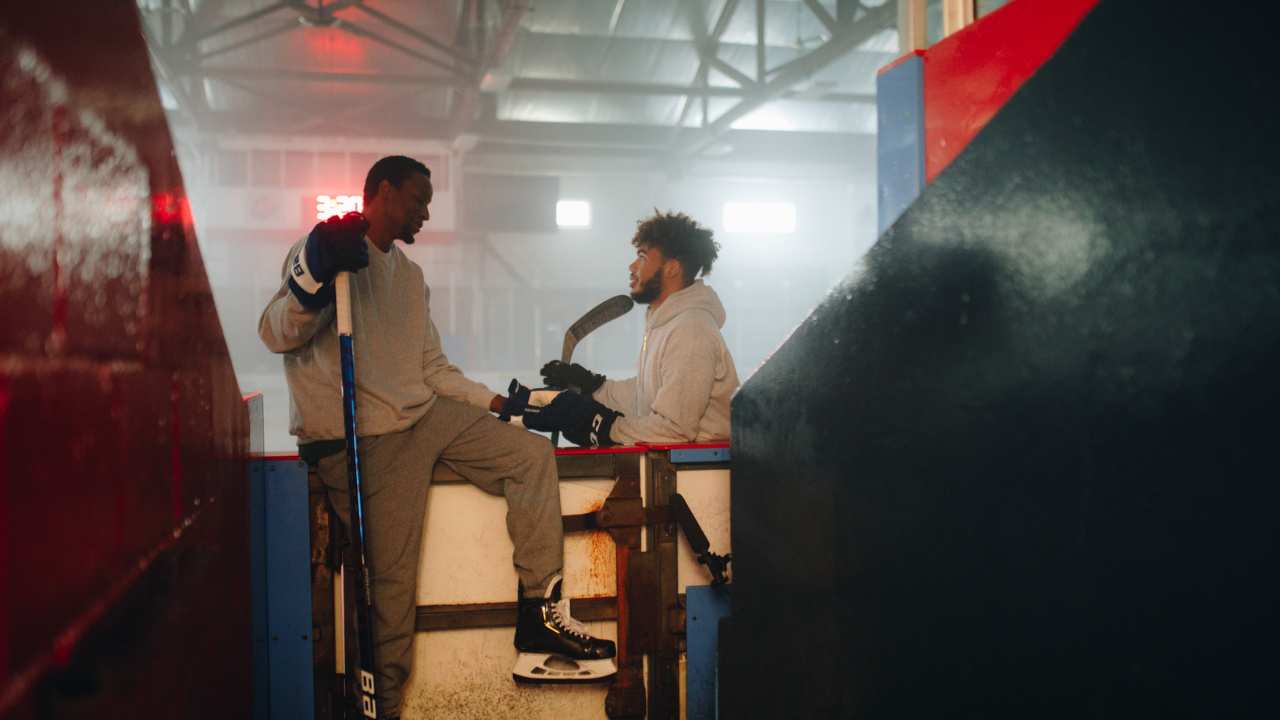 two men with hockey sticks talking