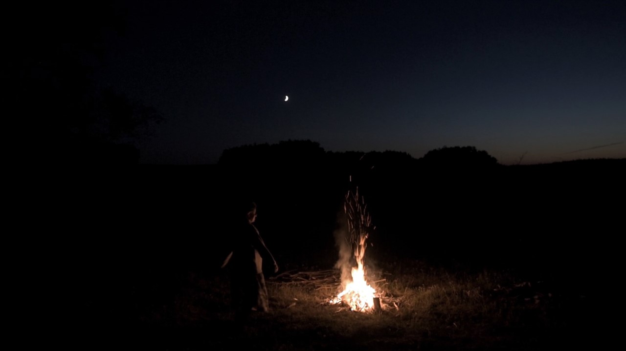 Nightime, person by fire, moon shining