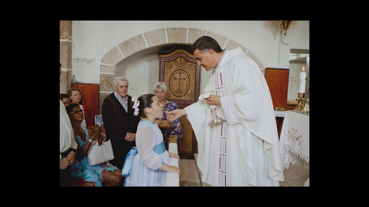 Kid in frilly dress accepting communion