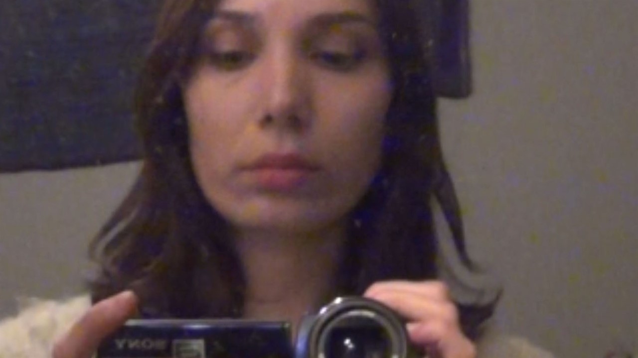 Woman filming herself in mirror