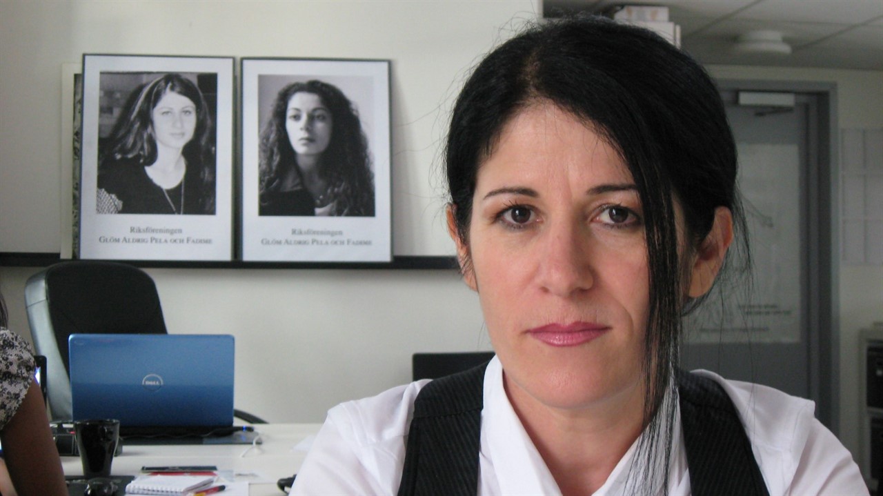 Woman in an office with two photos behind her