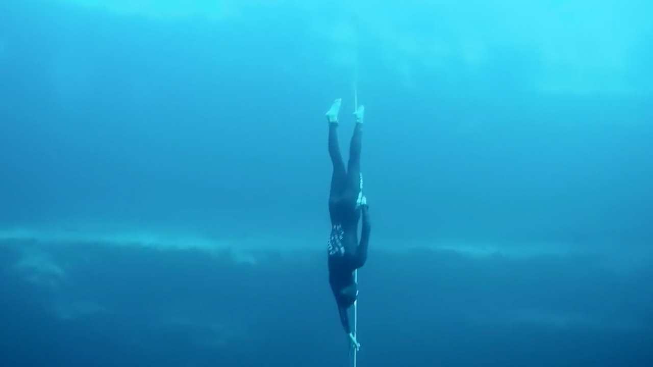 a person in a wetsuit holding onto a rope