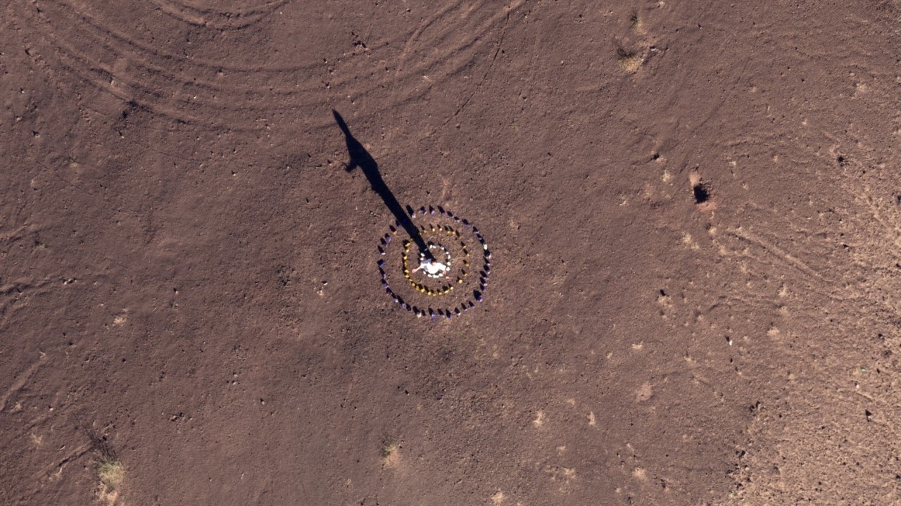 Aerial of man in desert in the middle of circles o
