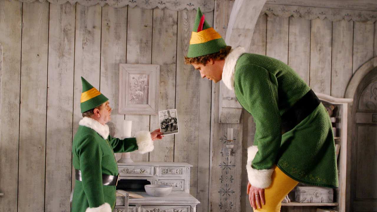 two elves looking at a photograph