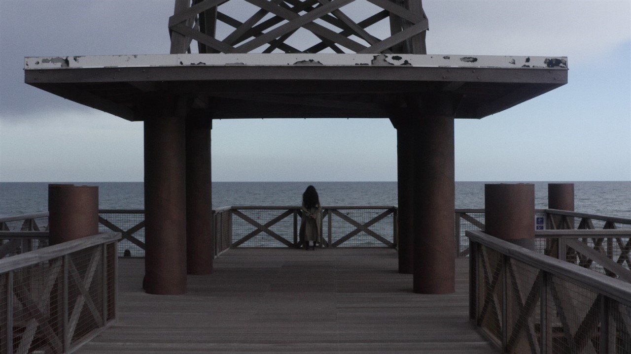 Woman on a pier looking at the water