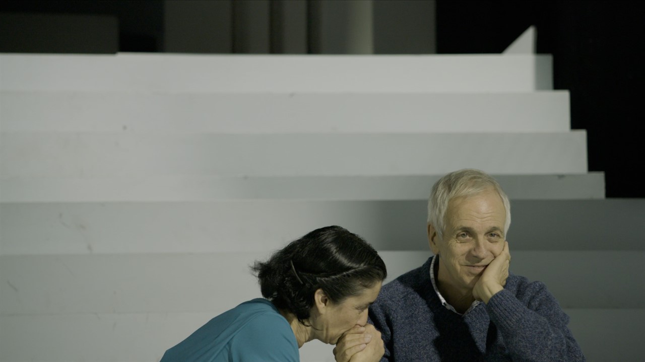 A smiling man in the lower righthand corner with a