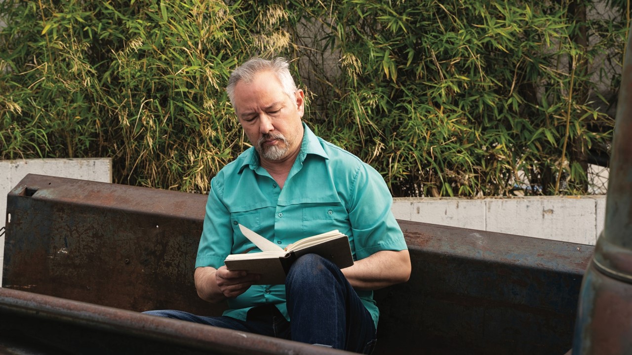 Man reading book outdoors