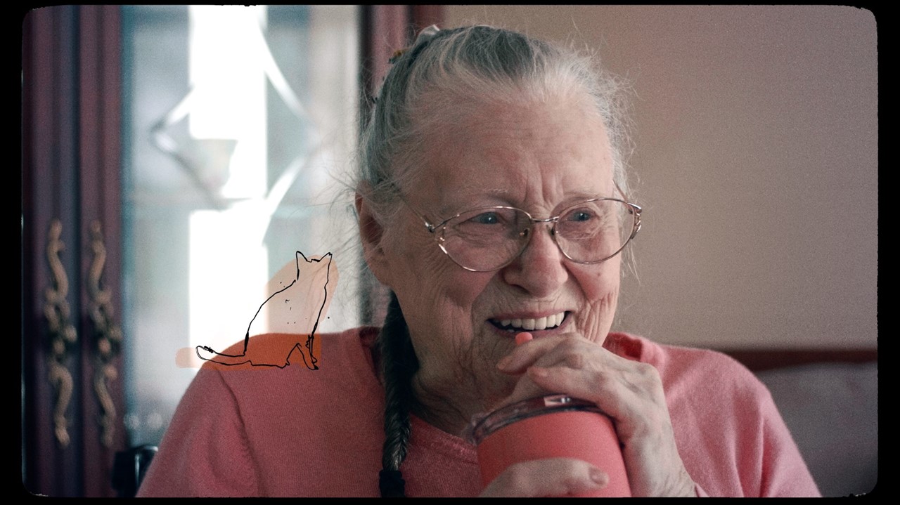 Old woman smiling and drinking through a straw