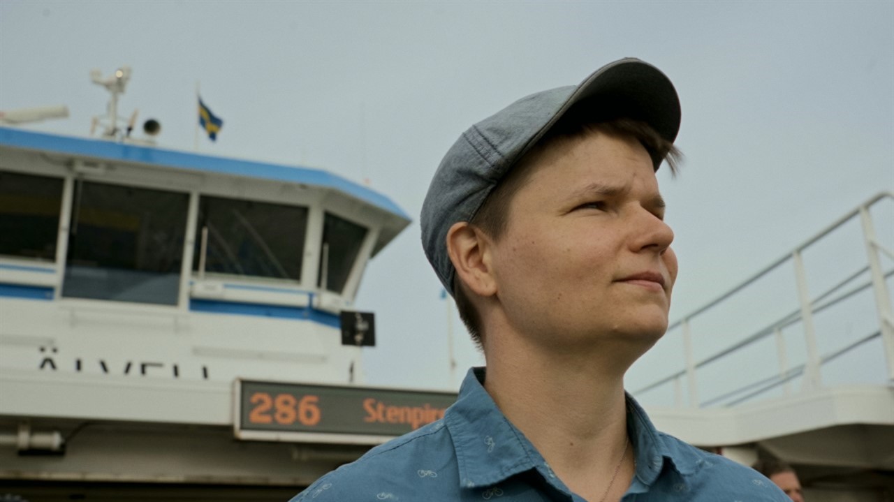 Person in a brimed hat with short hair