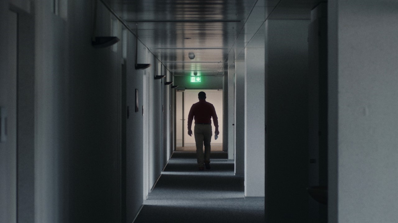 A person walks down a dimly lit hallway
