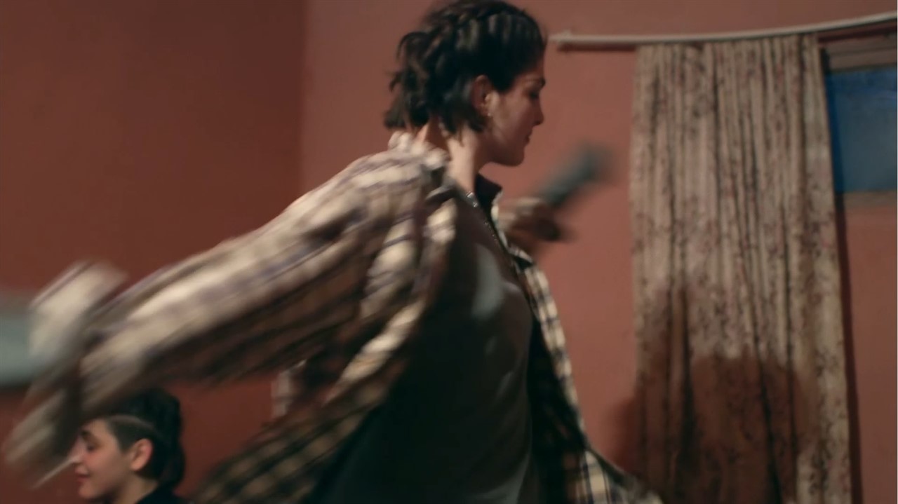 A person in a flannel twirling around 