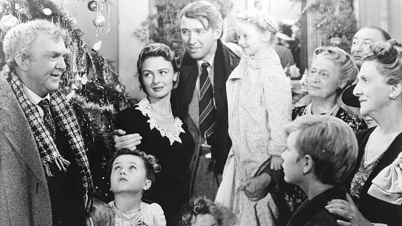 a group of people talking in front of a Xmas tree
