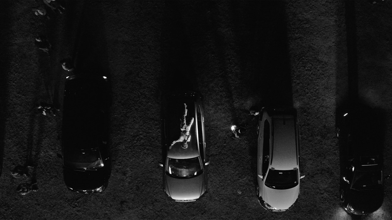 Aerial view of 4 vans parked in a row with a perso