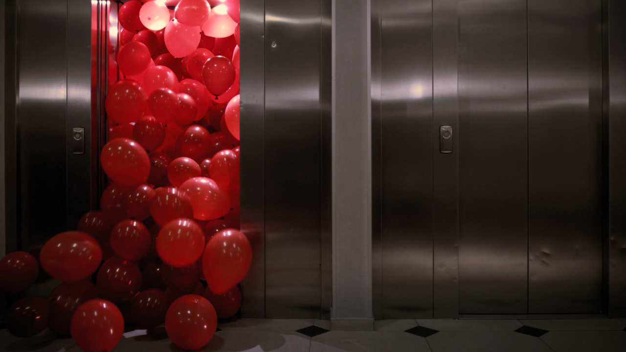 an elevator with red balloons
