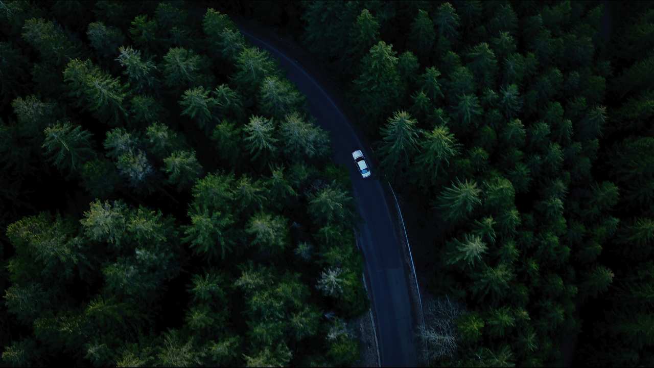 an aerial view of a car driving along a road