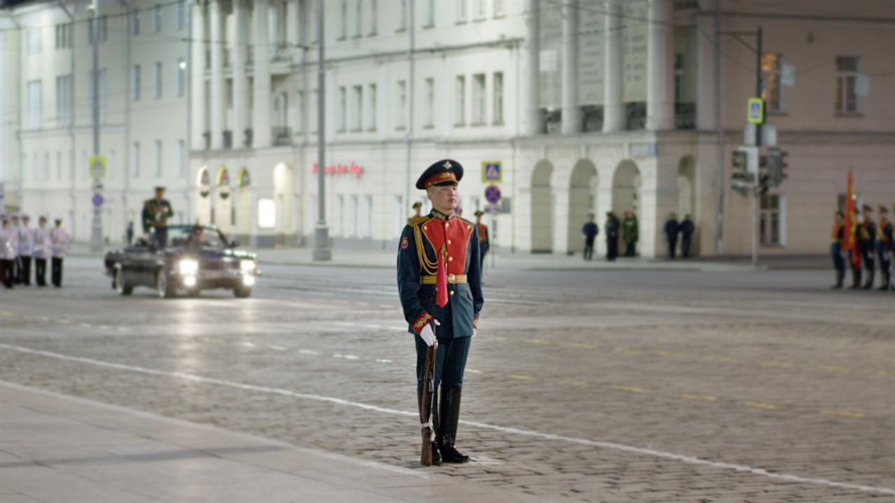 Man dressed in soldier regalia stands with a rifle