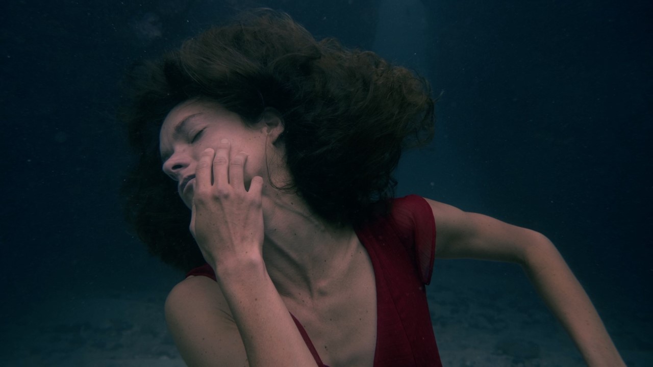 Woman underwater with eyes shut