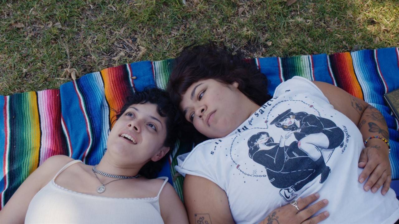 Two Latinx women laying on a blanket