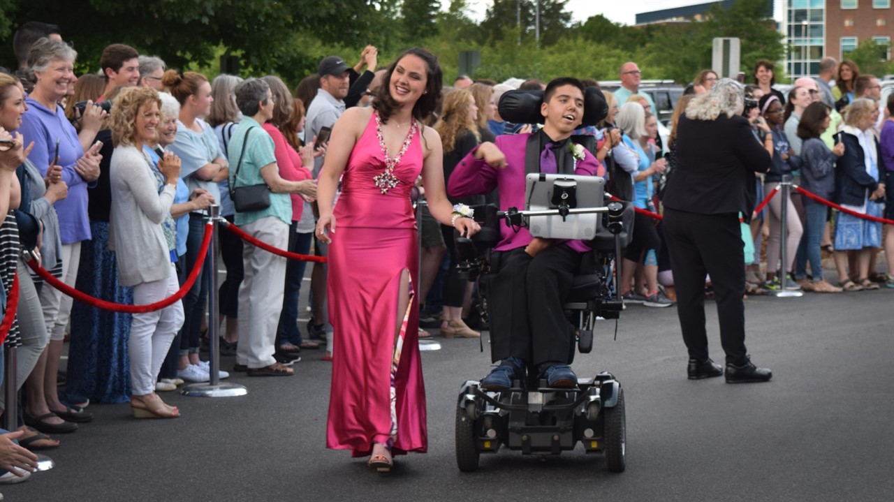 Woman and man in motorized chair dress for event