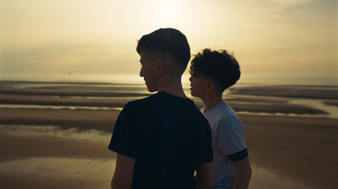 Two boys from behind looking at an out of focus la