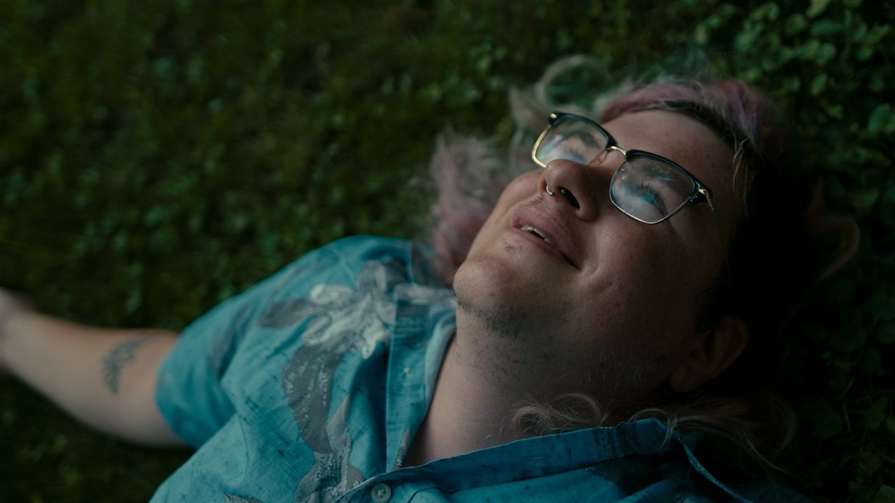 Man with glasses laying on the grass