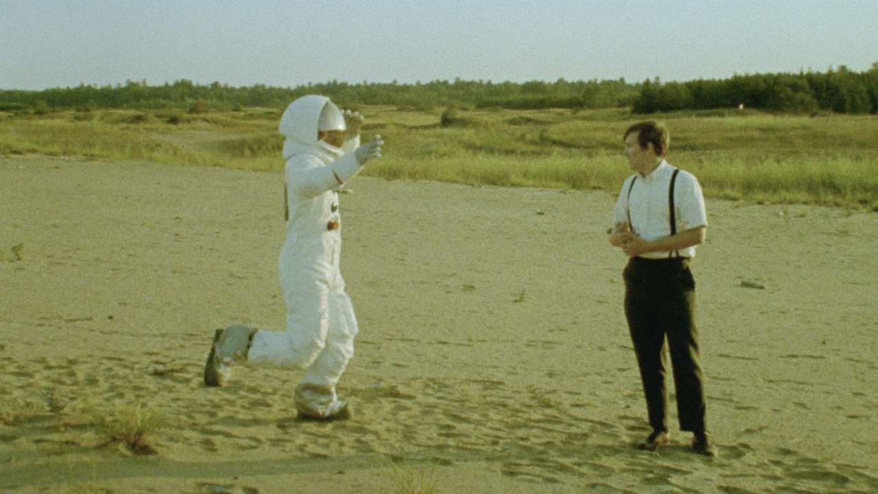 a person in a spacesuit running towards a man