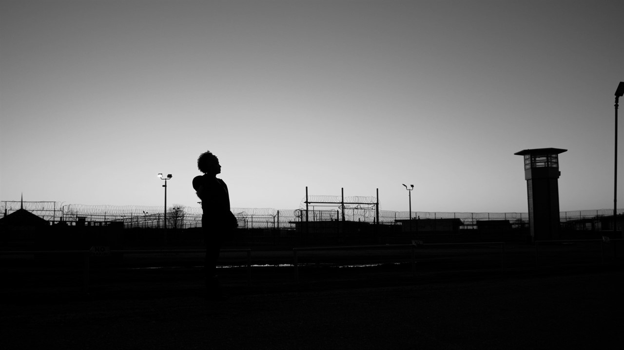 Woman in distance in front of prison