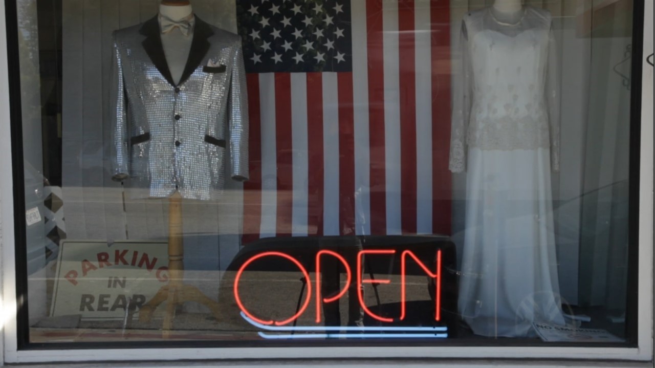 Window with a US flag, silver blazer and a dress