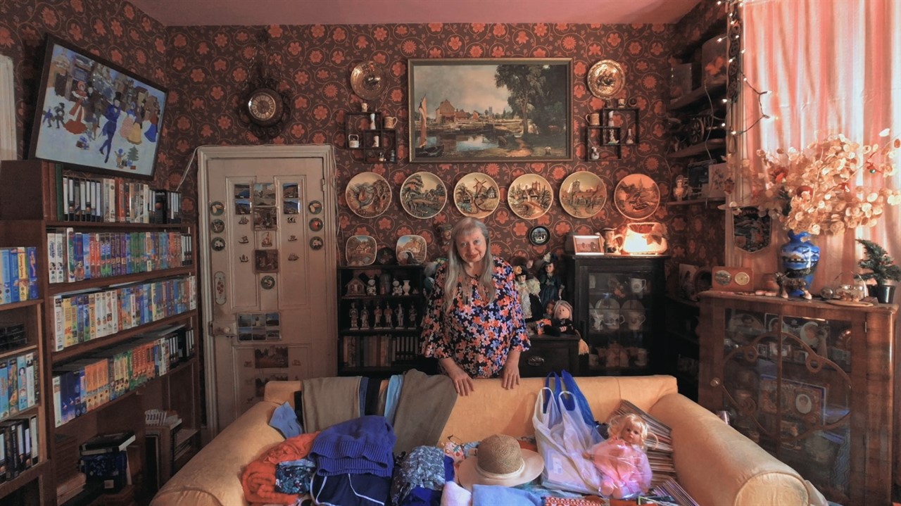 Woman in room with VHS tapes, decorative plates