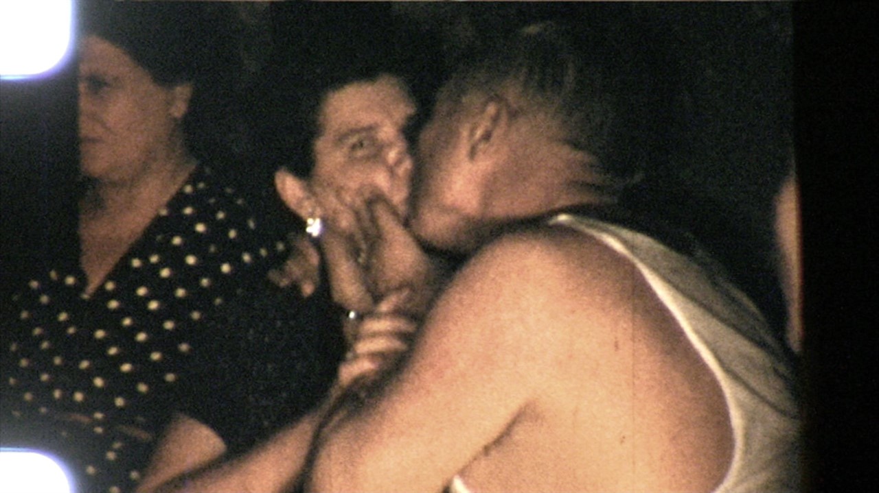 Photograph of a man kissing a woman