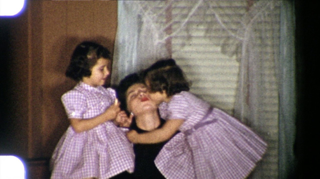 Photograhp of two girls kissing their mom