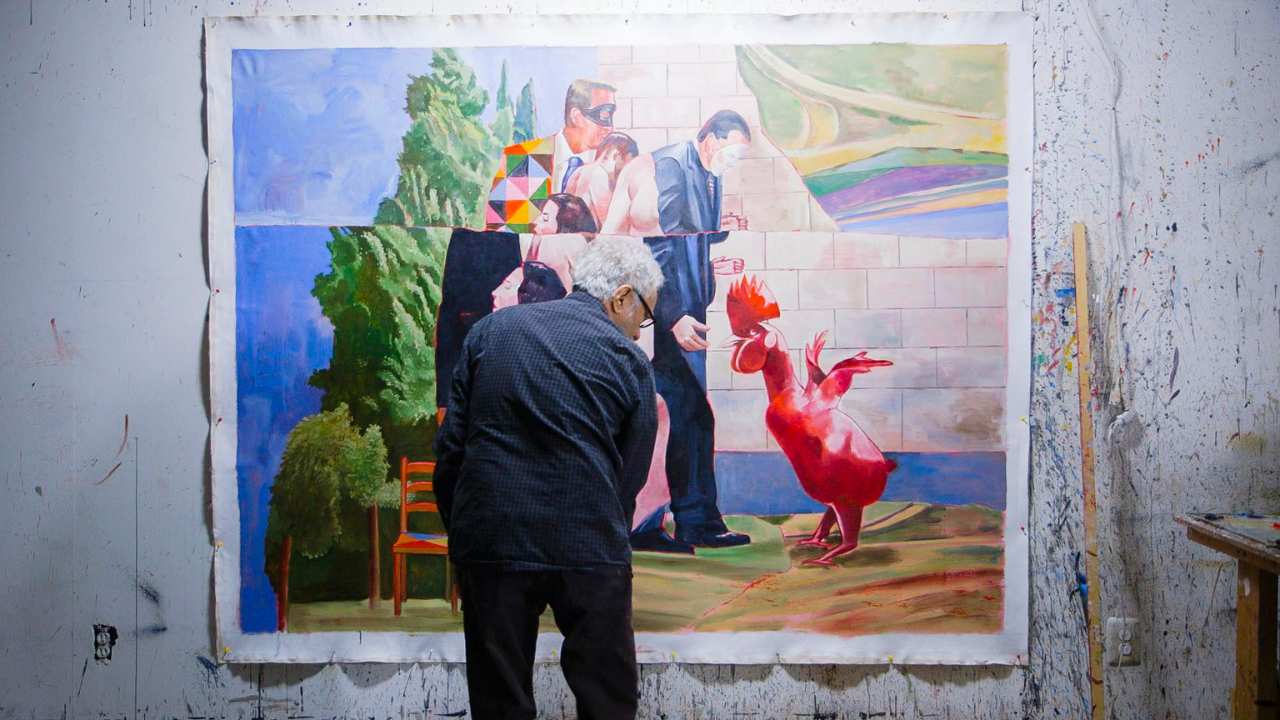 a man painting a canvas on a wall