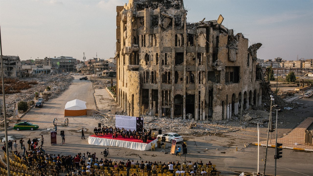 Orchestral concert in front of crumbling building