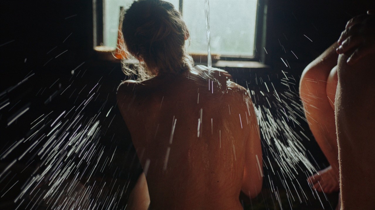 Topless woman's back with water splashing