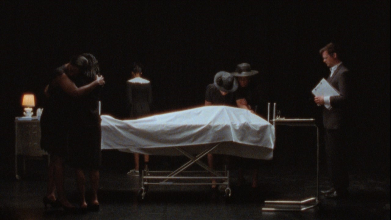 Women in black mourning a covered corpse