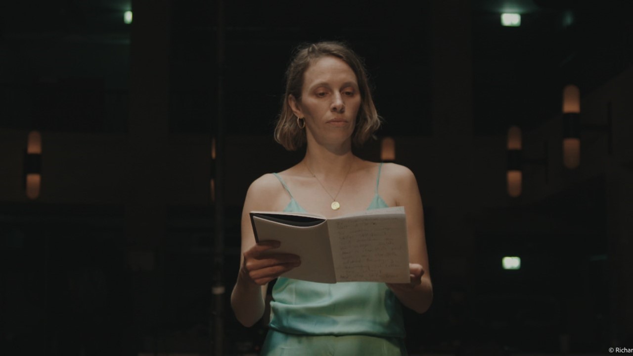 Woman with short hair reading a notebook