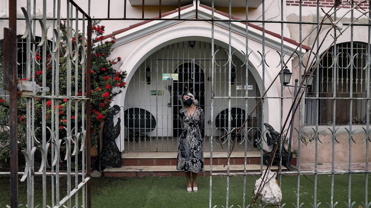 Woman in front of house with many metal gates