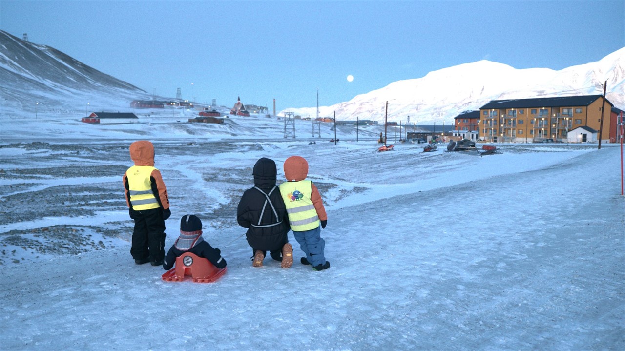 A group of children look at a small town